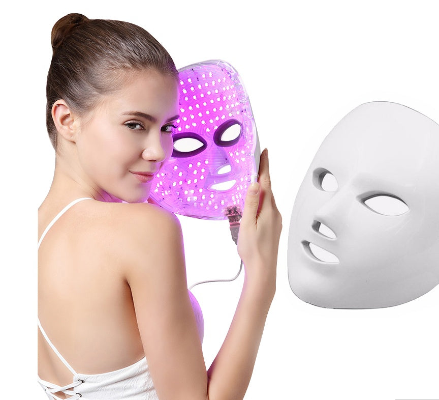 Woman holding a LED face mask with a white background