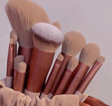 Set of makeup brushes with brown handles and beige bristles in a basket.
