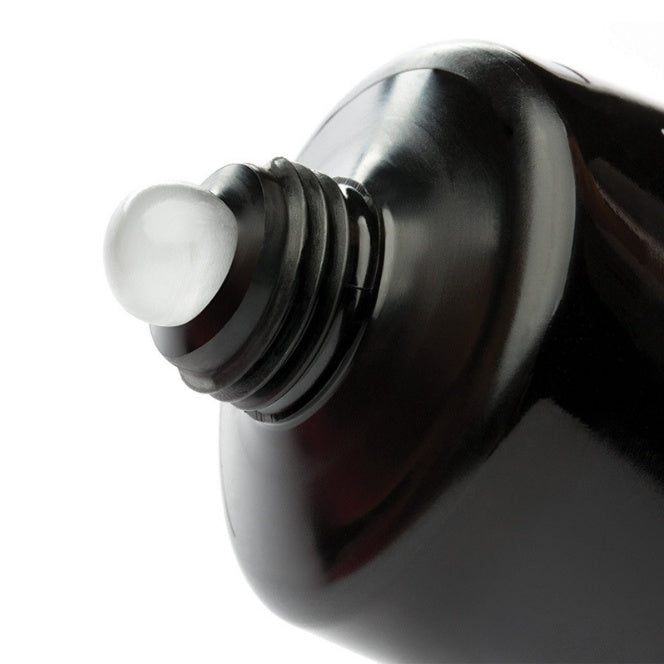 Close-up of a black bottle cap with a white cap on a white background