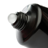 Close-up of a black bottle cap with a white cap on a white background