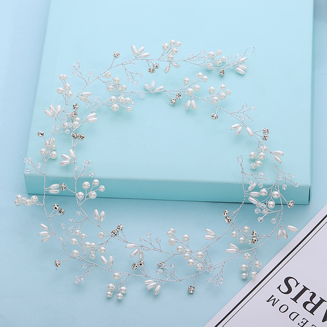 Decorative headpiece with pearls and crystals on a light blue background