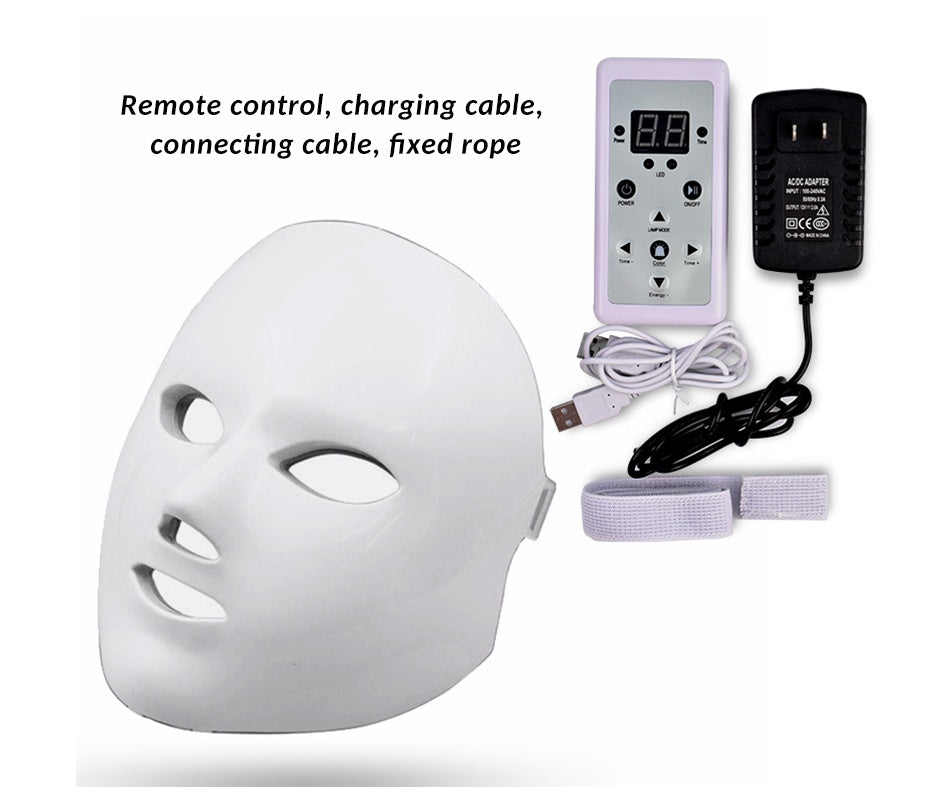 White LED face mask with remote control, charging cable, and power adapter on a white background