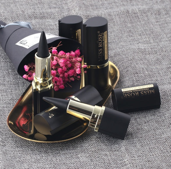 Miss Rose lipsticks on a textured surface with pink flowers.