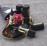 Miss Rose lipsticks on a textured surface with pink flowers.