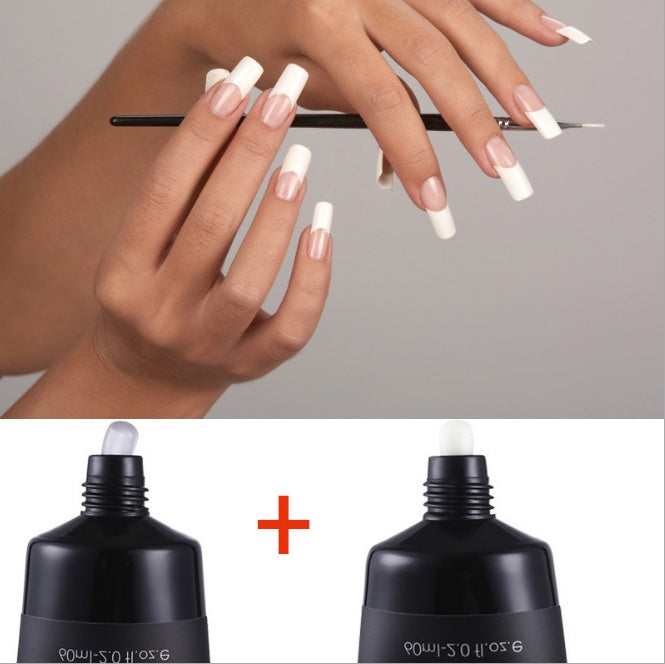 Close-up of hands with white nail polish holding a pen, with two black nail polish bottles below.
